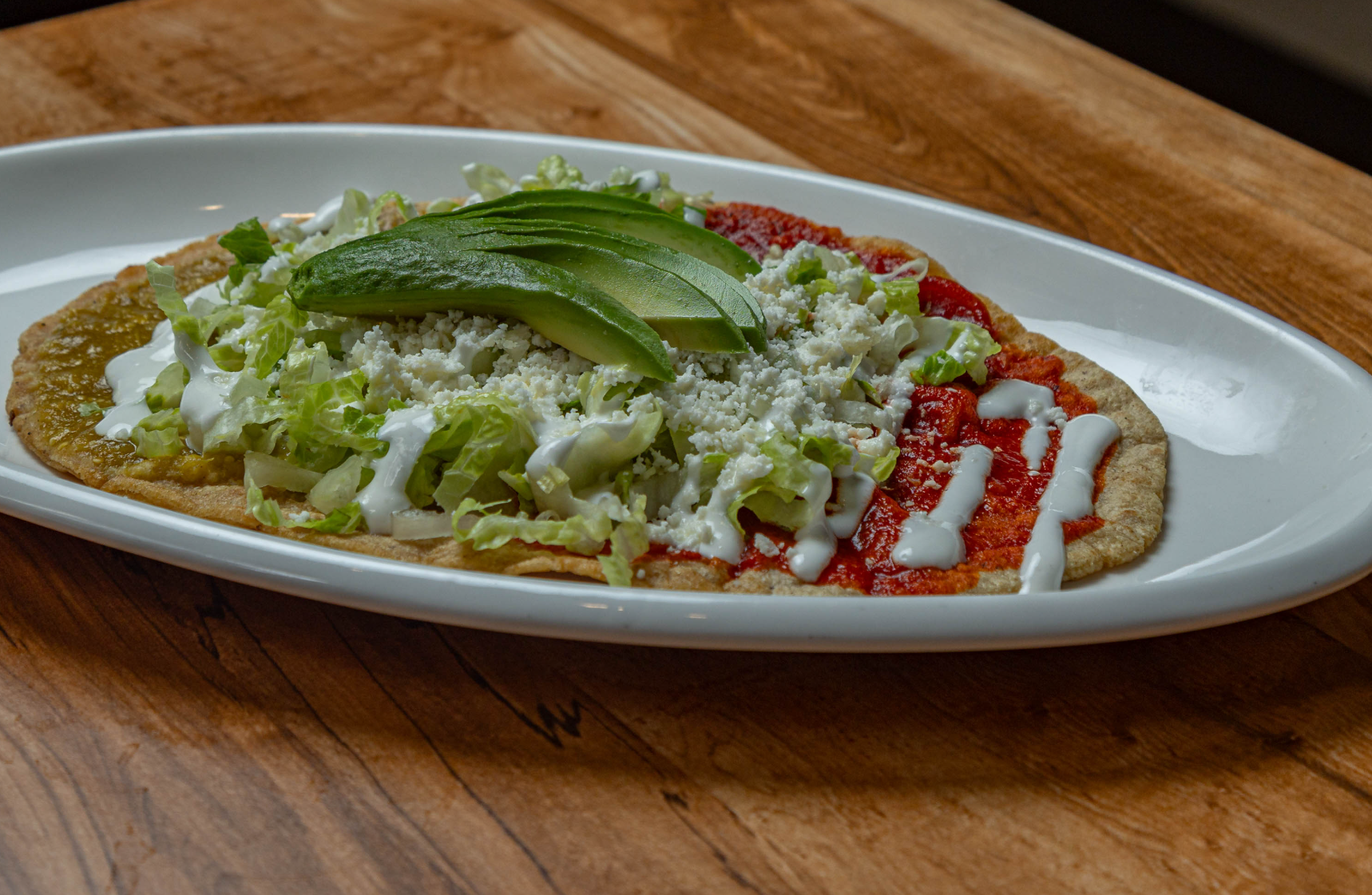 Mexican huaraches topped with greens, avocado and plant-based toppings